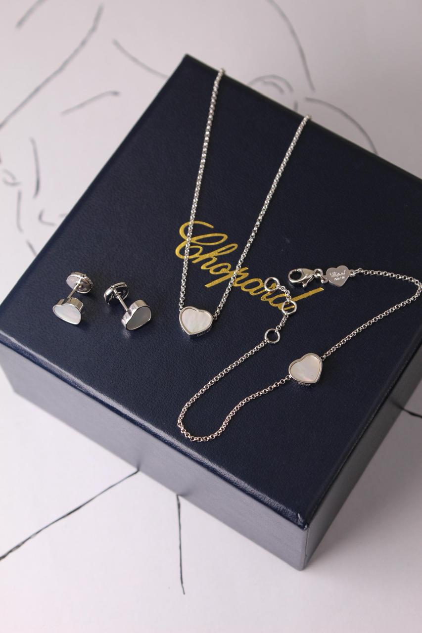 Chopard Happy Hearts-Inspired Three-Piece Jewelry Set — -Tone Heart Pendant Necklace, Matching Stud Earrings & Delicate Chain Bracelet with White Mother-of-Pearl Heart Motifs.